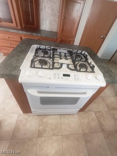 interior details with brown cabinetry and white range with gas cooktop