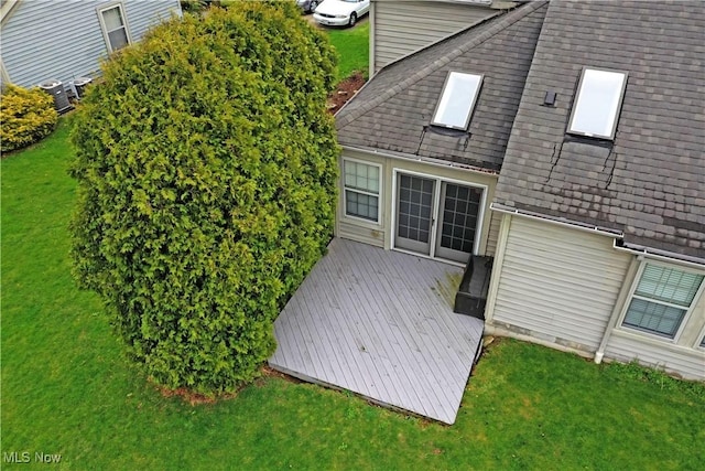 345 S Linden Ct, Warren, OH 44484 - back of property with a shingled roof, a deck, cooling unit, and a lawn