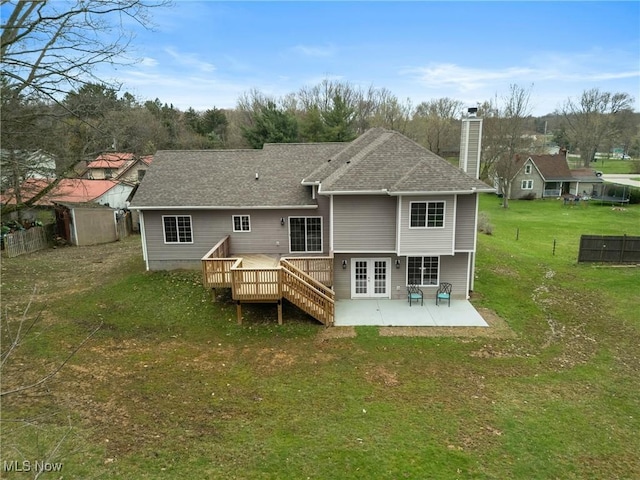 back of property with a lawn, a chimney, a patio, fence, and french doors