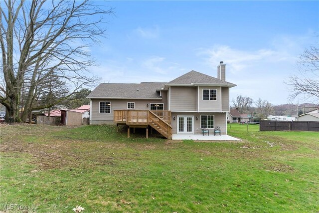 back of house with french doors, a yard, fence, and a chimney