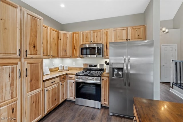 kitchen featuring dark wood finished floors, appliances with stainless steel finishes, light brown cabinetry, and butcher block counters