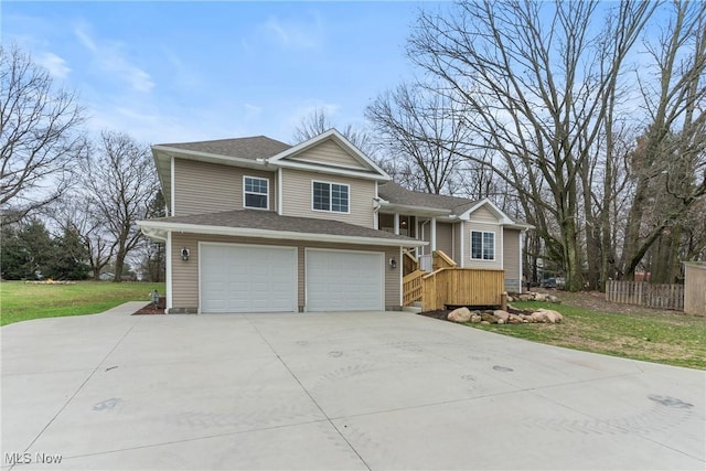 tri-level home featuring a garage, fence, a front lawn, a shingled roof, and concrete driveway