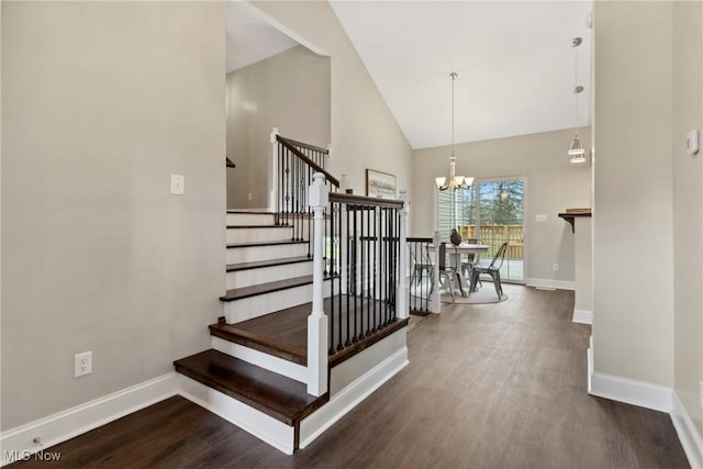 stairway featuring high vaulted ceiling, baseboards, a chandelier, and wood finished floors