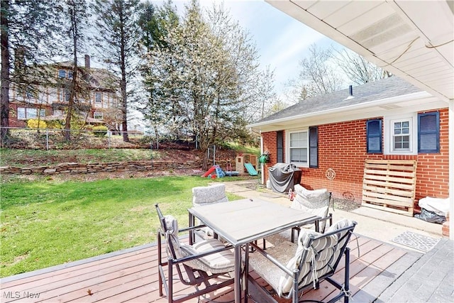 deck with a yard, fence, and outdoor dining area