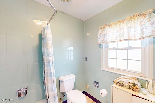 full bathroom featuring toilet and tiled shower