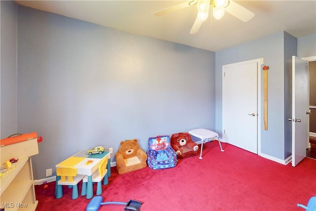 recreation room with carpet floors, ceiling fan, and baseboards