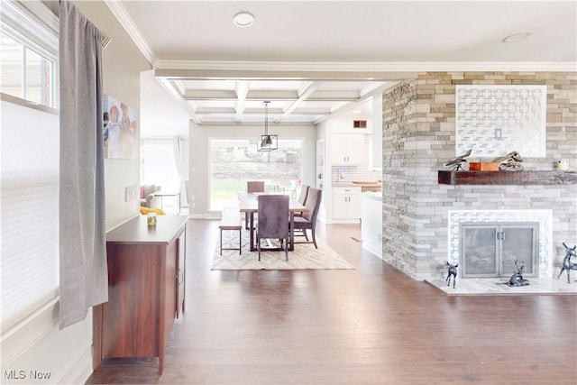 dining area with coffered ceiling, crown molding, a healthy amount of sunlight, and wood finished floors