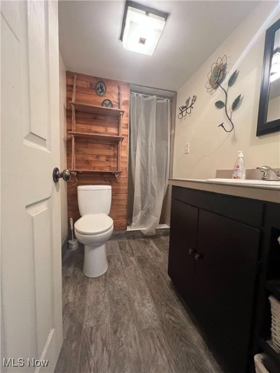 full bath featuring wood finished floors, toilet, vanity, and a shower with curtain