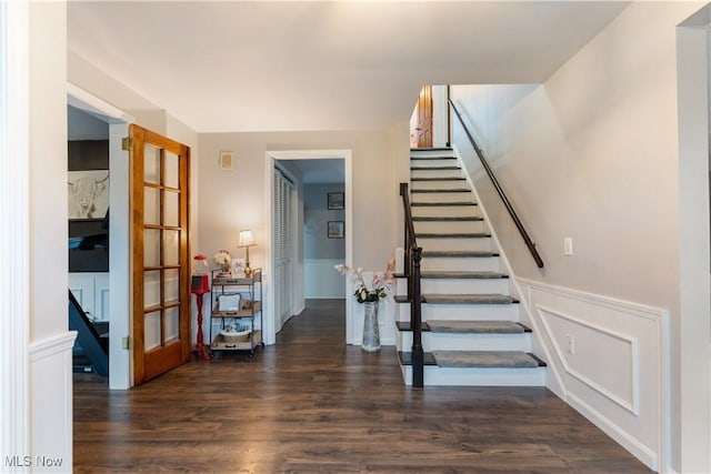 2119 Devonshire Dr NW, Canton, OH 44708 - stairway featuring a decorative wall, french doors, wainscoting, and wood finished floors