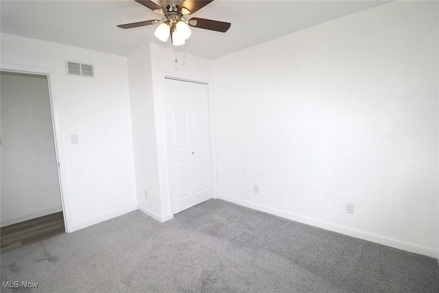 unfurnished bedroom with a closet, baseboards, visible vents, ceiling fan, and carpet floors