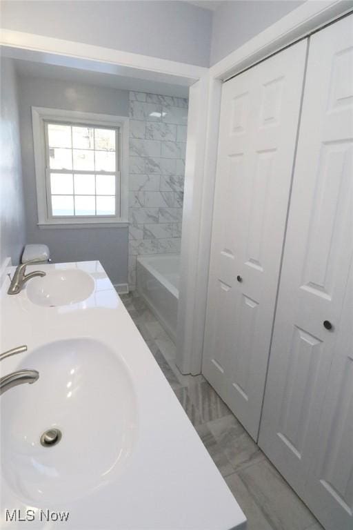 bathroom with a sink and marble finish floor