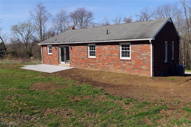 back of property featuring a patio, brick siding, central AC unit, and a lawn