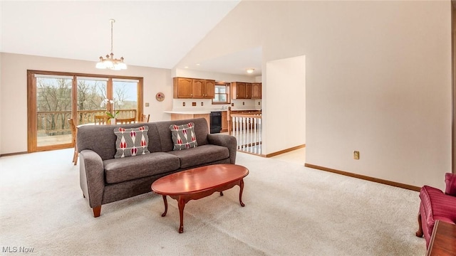 living area featuring light carpet, high vaulted ceiling, baseboards, and an inviting chandelier