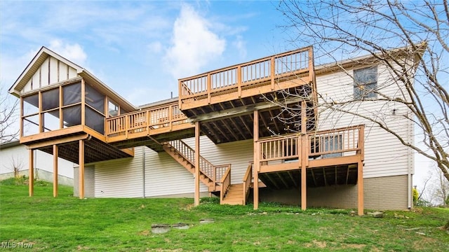 rear view of house featuring a wooden deck, a sunroom, a lawn, and stairs