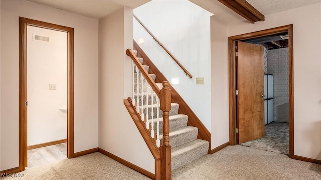 stairs featuring visible vents, beamed ceiling, baseboards, and carpet
