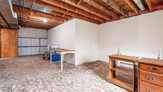 below grade area featuring carpet flooring and brick wall