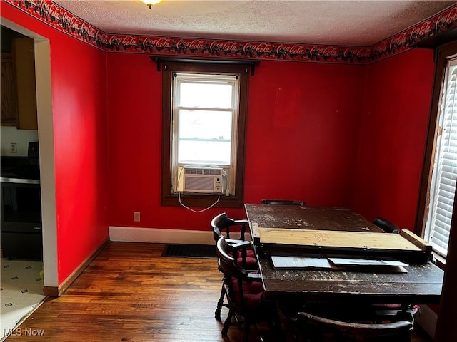 dining area featuring baseboards, cooling unit, a textured ceiling, and wood finished floors