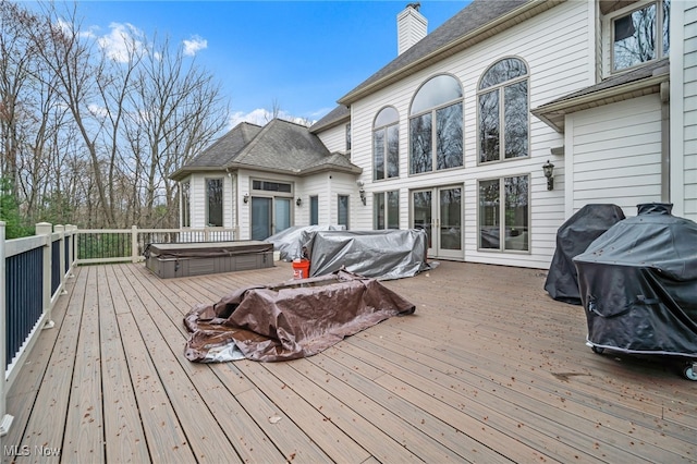 wooden terrace with area for grilling and a covered hot tub