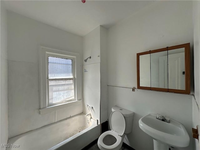 full bathroom featuring toilet, a sink, and washtub / shower combination