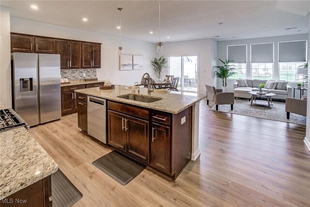 850-4 Dipper Ln, Aurora, OH 44202 - kitchen with a sink, appliances with stainless steel finishes, dark brown cabinetry, light wood finished floors, and light stone countertops