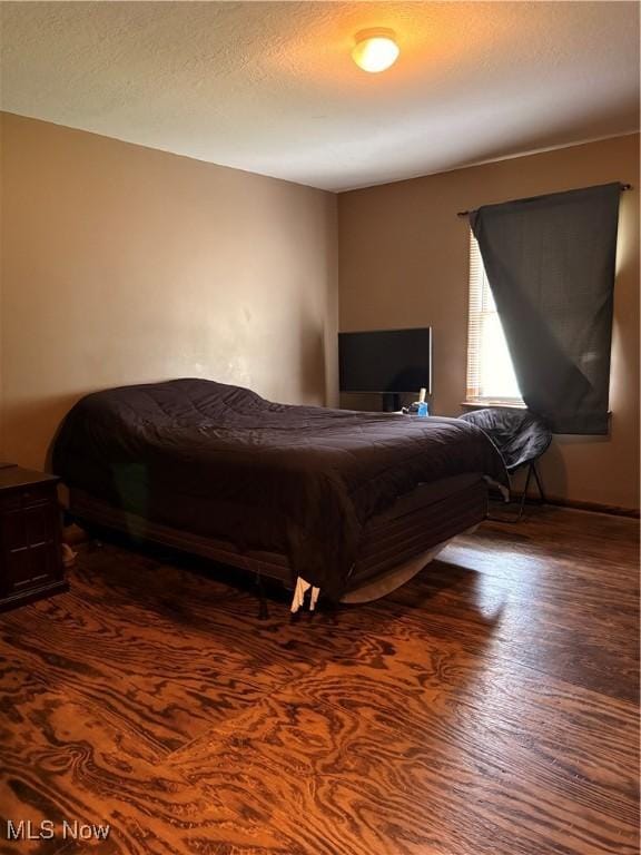 bedroom with wood finished floors and a textured ceiling
