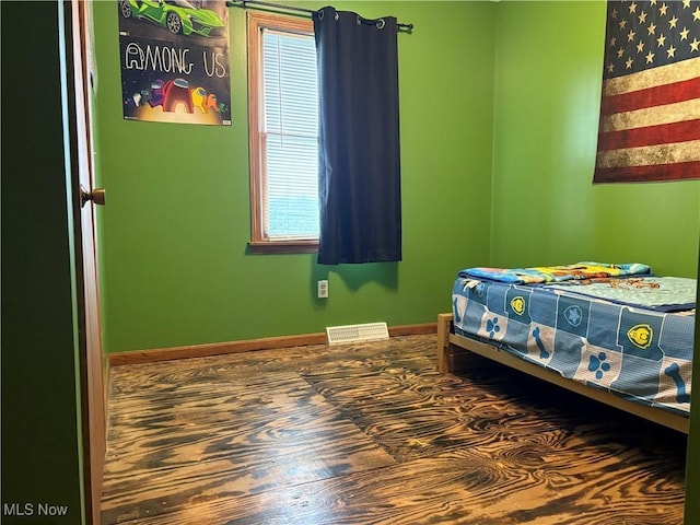 bedroom with visible vents, baseboards, and multiple windows