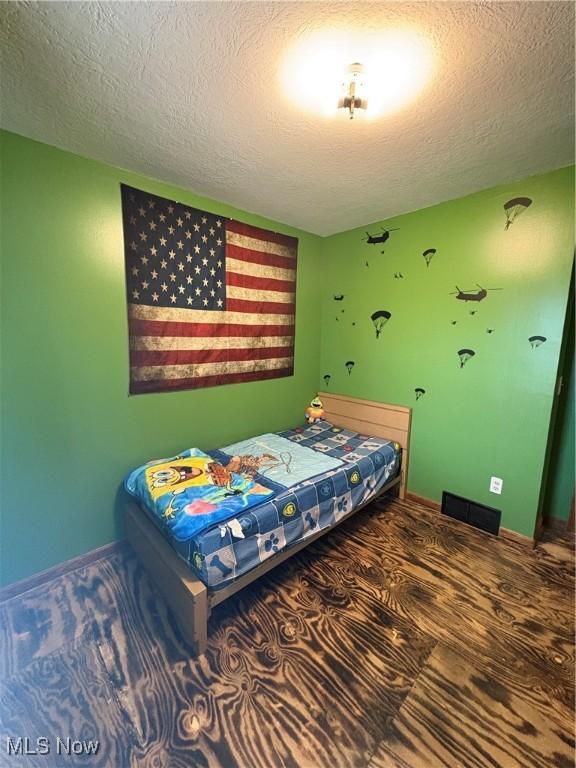 bedroom with baseboards and a textured ceiling