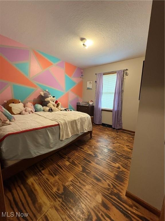 bedroom featuring a textured ceiling and baseboards