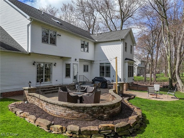 back of house featuring a yard, entry steps, an outdoor fire pit, a patio, and roof with shingles