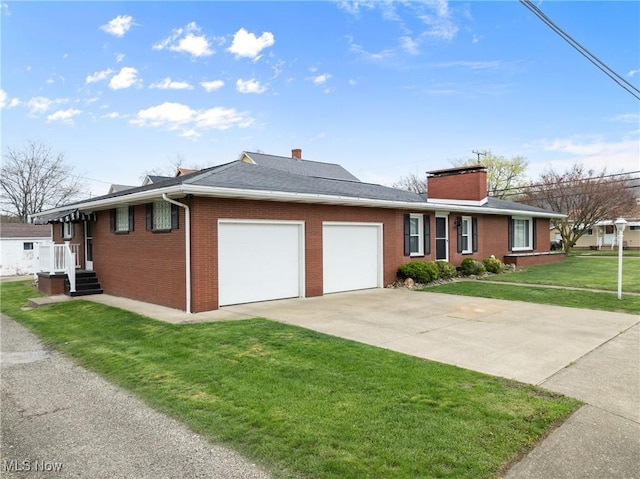 view of front of property with concrete driveway, a chimney, a front lawn, an attached garage, and brick siding