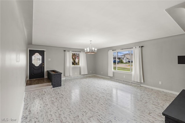 unfurnished living room with a notable chandelier, a baseboard heating unit, wood finished floors, and baseboards