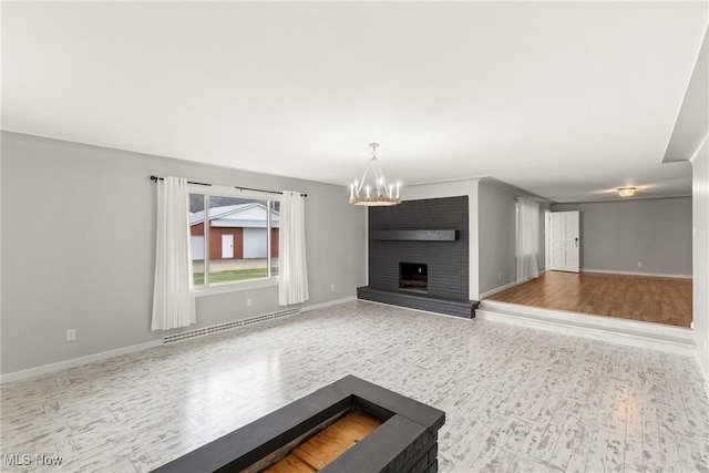 unfurnished living room featuring an inviting chandelier, a baseboard heating unit, and wood finished floors