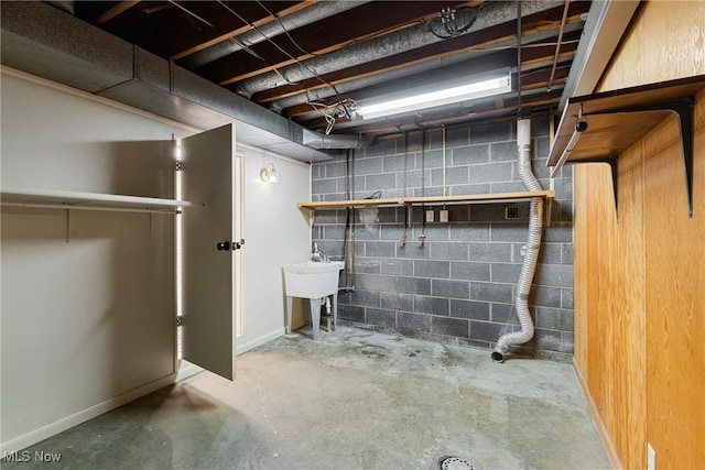 unfinished below grade area with a sink and concrete block wall