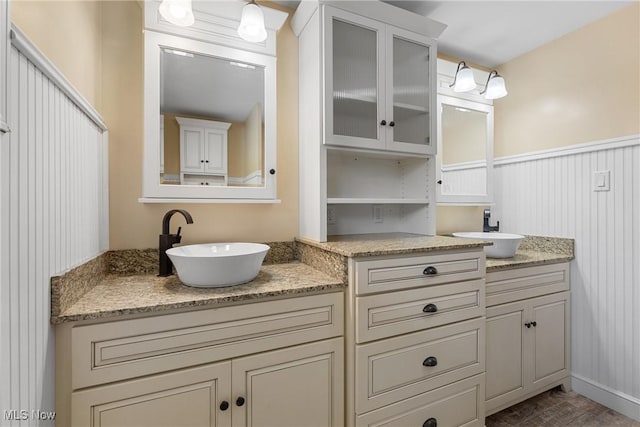 bathroom featuring two vanities, a sink, and wood finished floors