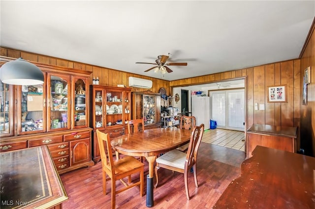 2262 Tanglewood Dr, Salem, OH 44460 - dining area featuring wood walls, a ceiling fan, a wall mounted air conditioner, and wood finished floors