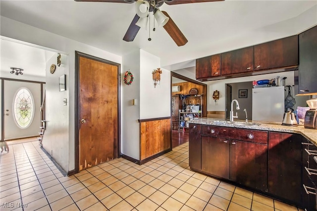 2262 Tanglewood Dr, Salem, OH 44460 - kitchen with a ceiling fan, white fridge, light tile patterned floors, a peninsula, and light stone counters