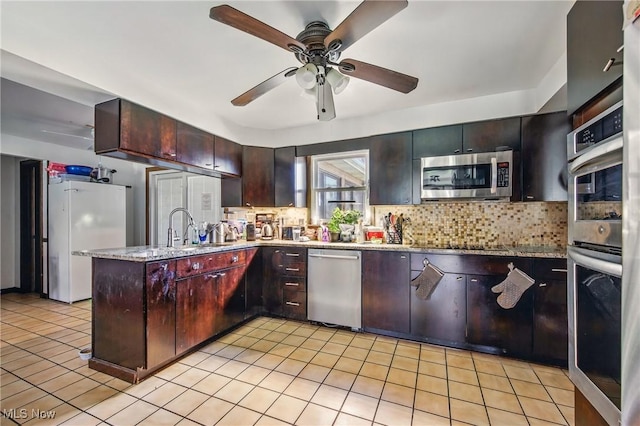 2262 Tanglewood Dr, Salem, OH 44460 - kitchen featuring appliances with stainless steel finishes, backsplash, light tile patterned floors, ceiling fan, and a peninsula