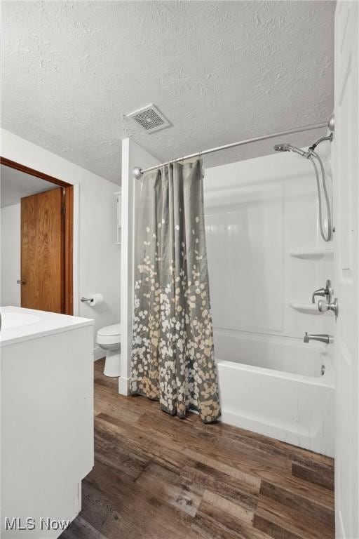 full bathroom with shower / bath combination with curtain, a textured ceiling, visible vents, toilet, and wood finished floors