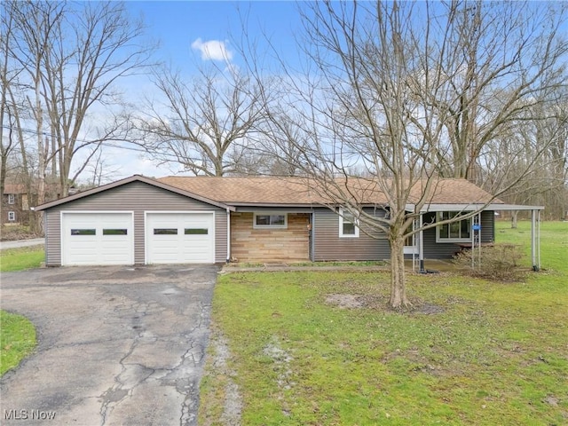 view of front of house with a front lawn, an attached garage, driveway, and roof with shingles