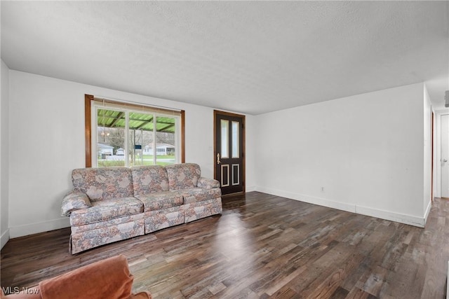 living room with baseboards, a textured ceiling, and wood finished floors