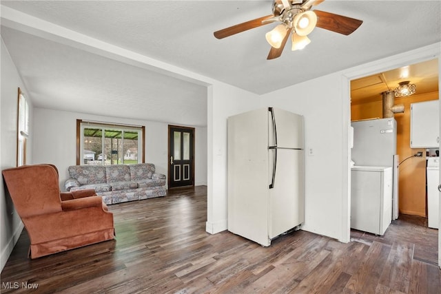 living area with wood finished floors, ceiling fan, and washer / dryer