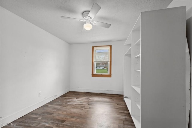 interior space featuring baseboards, a textured ceiling, a ceiling fan, and wood finished floors