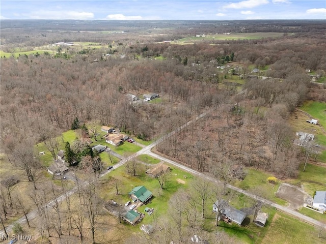 drone / aerial view with a wooded view