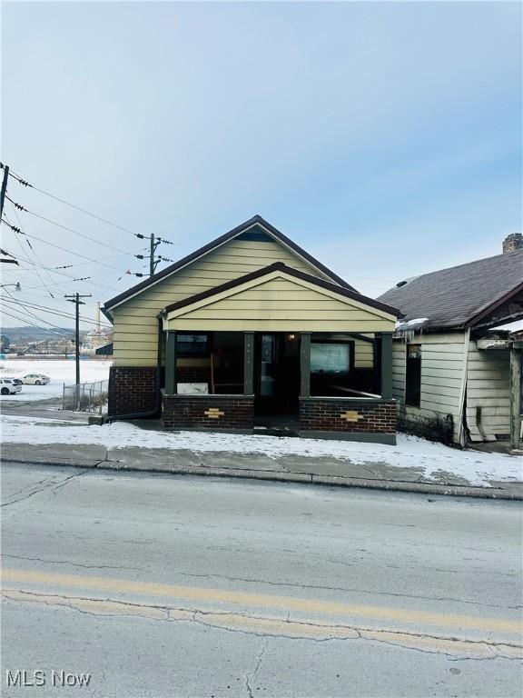 view of front facade featuring brick siding and a porch