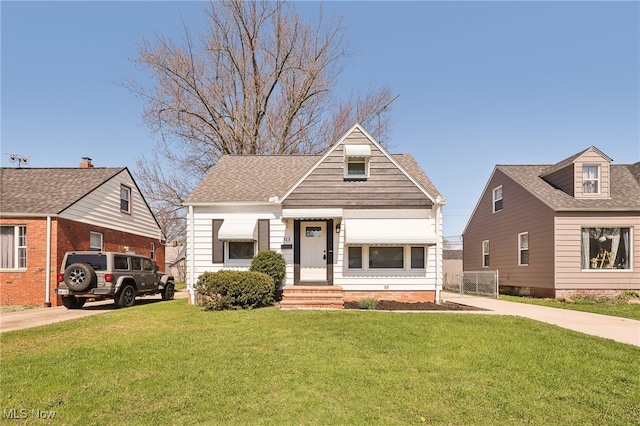 view of front of property with a front lawn and roof with shingles