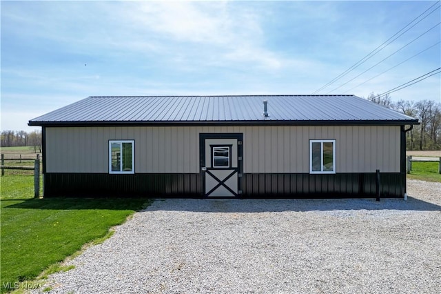 view of front of property with fence, metal roof, and a front lawn