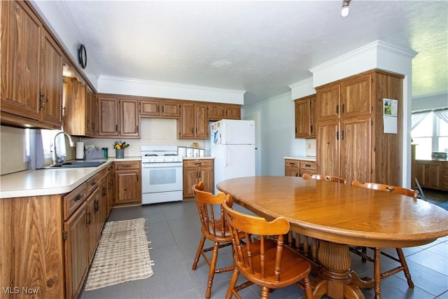 kitchen with a sink, brown cabinetry, and white appliances