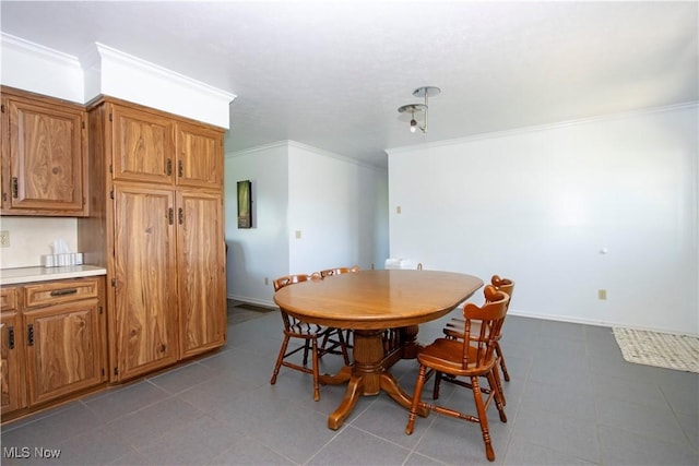 dining area featuring crown molding and baseboards
