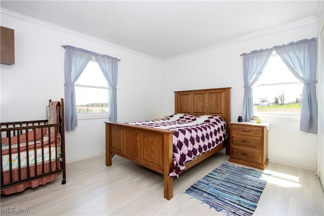bedroom featuring ornamental molding and light wood finished floors