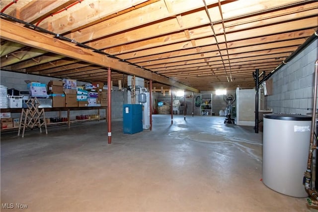 unfinished basement featuring a heating unit, water heater, and concrete block wall